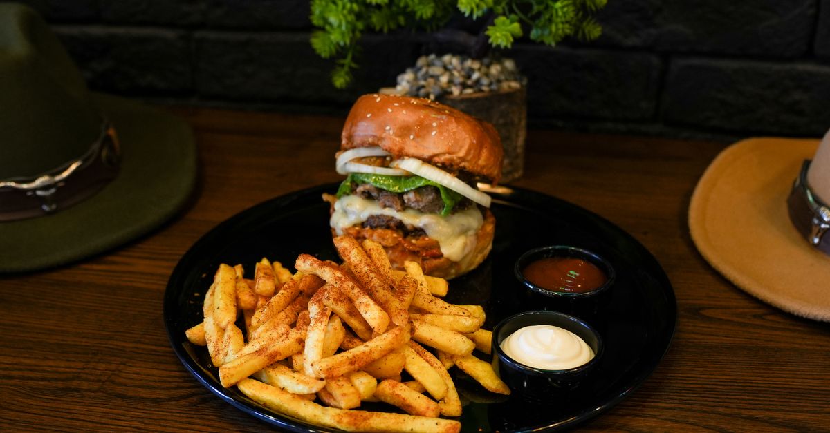 A gourmet burger and chips served on a plate in a casual burger restaurant