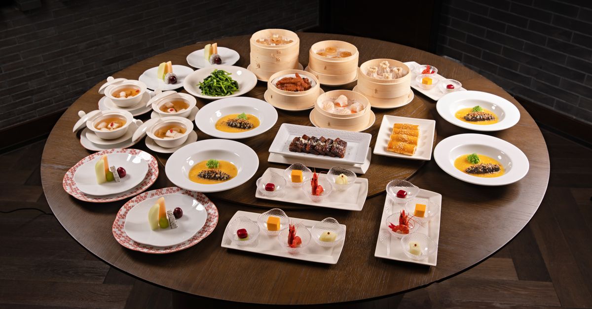 A large round table laid with dim sum and Chinese dishes to share