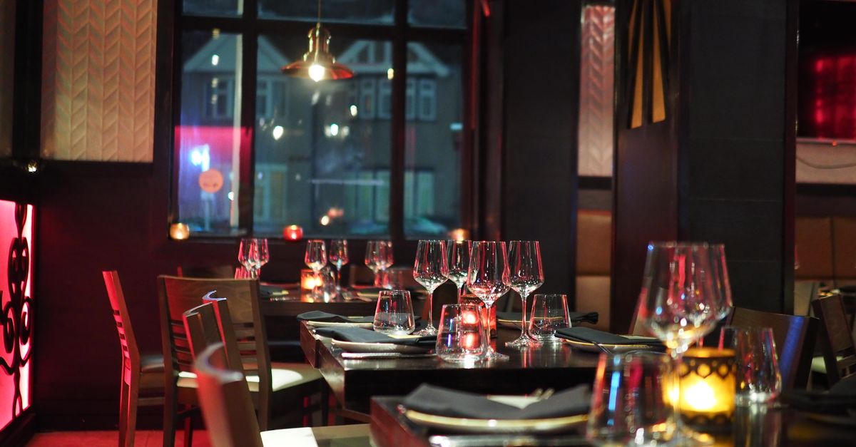 An intimate fine dining room with candlelit tables and polished wine glasses