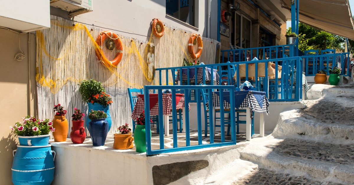 A blue-and-white Greek taverna terrace set for lunch