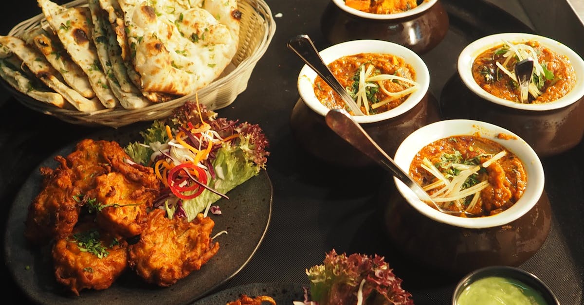An Indian restaurant spread of naan, curries and onion bhajis laid out to share