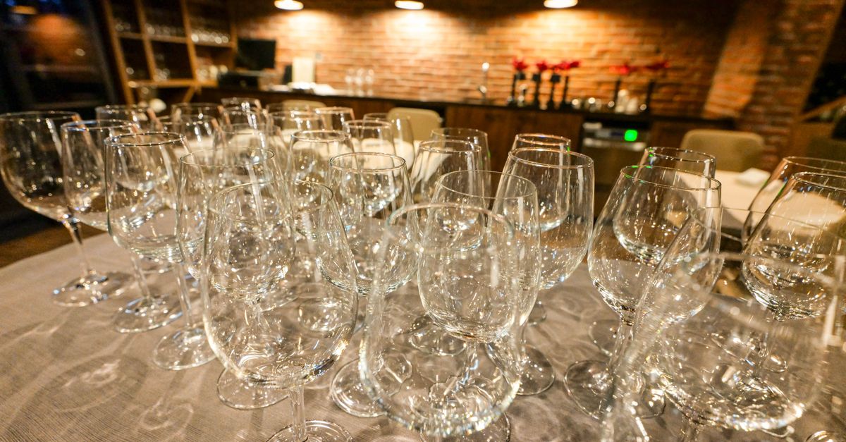 Rows of wine glasses set out on the counter of a cosy wine bar